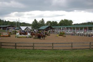 horses and riders gathered while onlookers cheer at the Blowing Rock Horse Show