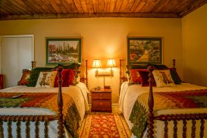 two queen beds lovingly decorated, hardwood ceilings, and cozy decor